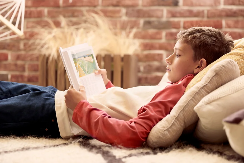 Kid reading a book after school to help calm after school meltdowns.