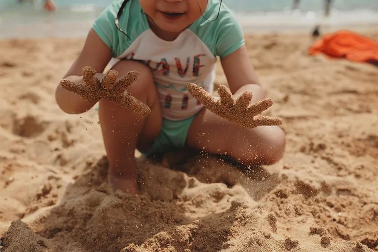 Kid playing with sand at the beach