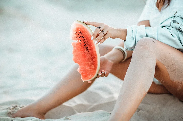 Eating watermelon as a beach day snack