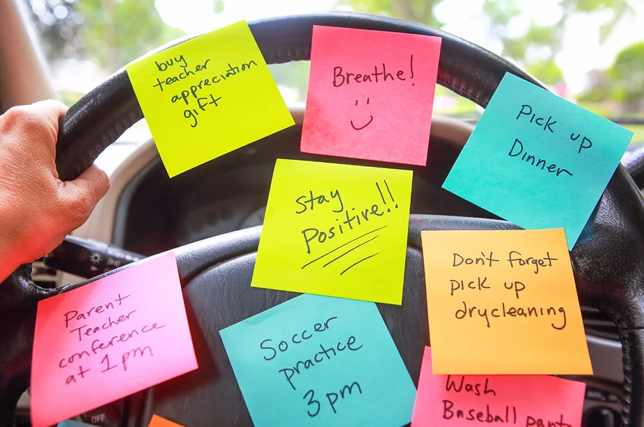 Sticky notes with things to do on steering wheel, demonstrating causes of autism mom burnout.