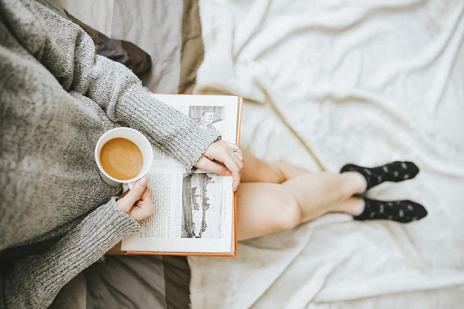 Mom reading a book and drinking coffee, a strategy to overcome autism mom burnout.