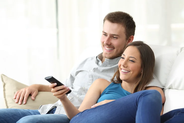 Parents enjoying an exciting movie date night at home