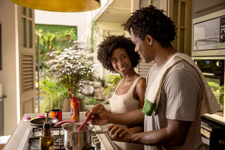 Parents enjoying an exciting date night cooking together at home