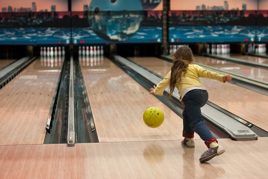 Kid bowling at a bowling alley,  a great one on one activity for kids and parents.