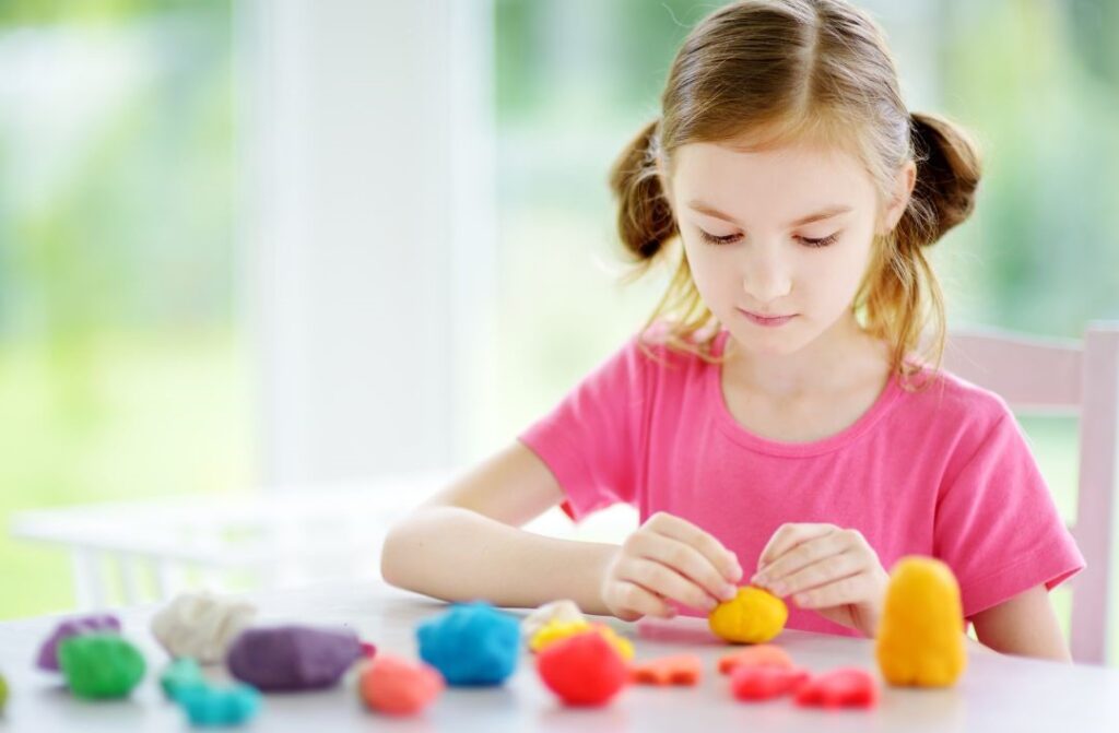 Child playing with playdoh as part of a sensory diet.