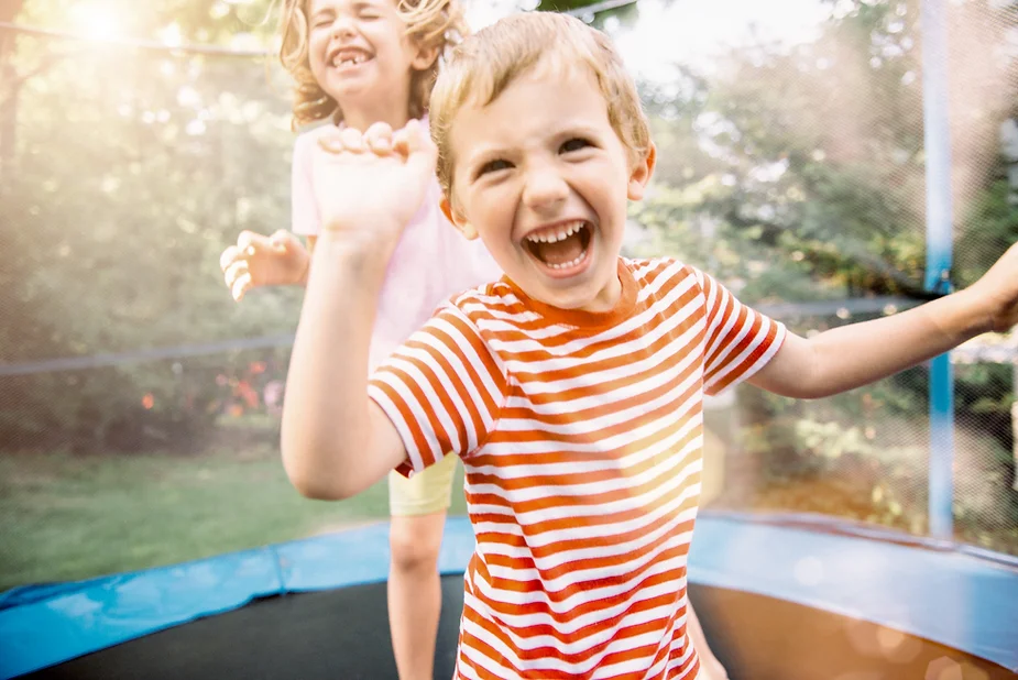 Autistic child jumping on trampoline, finding joy in the simple things.