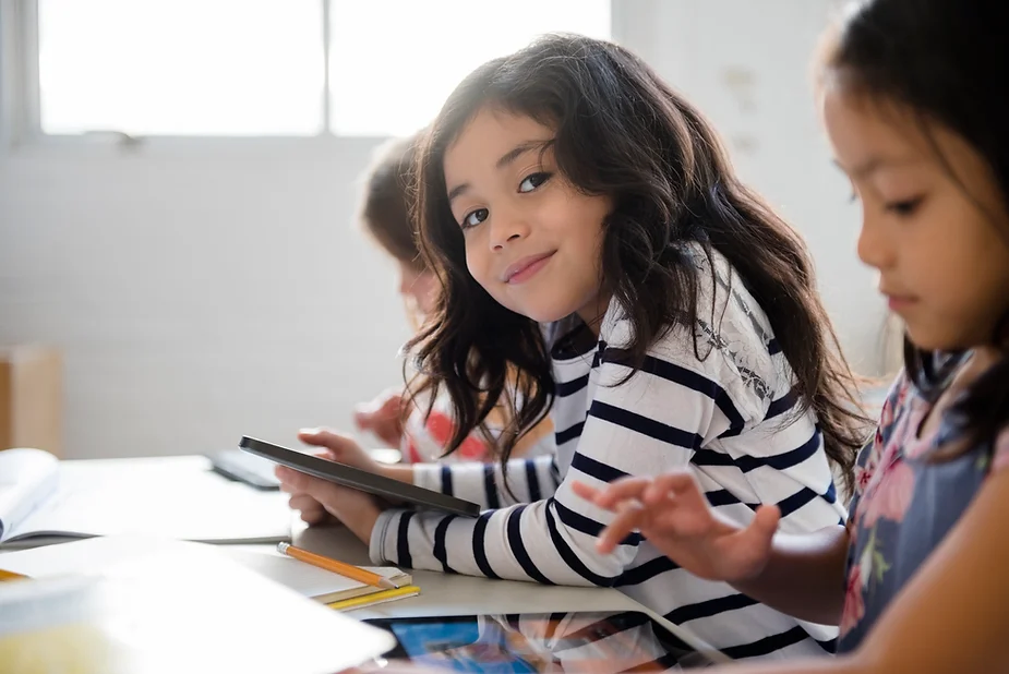 Happy girl in an inclusive classroom that uses classroom sensory tools and fidget toys.