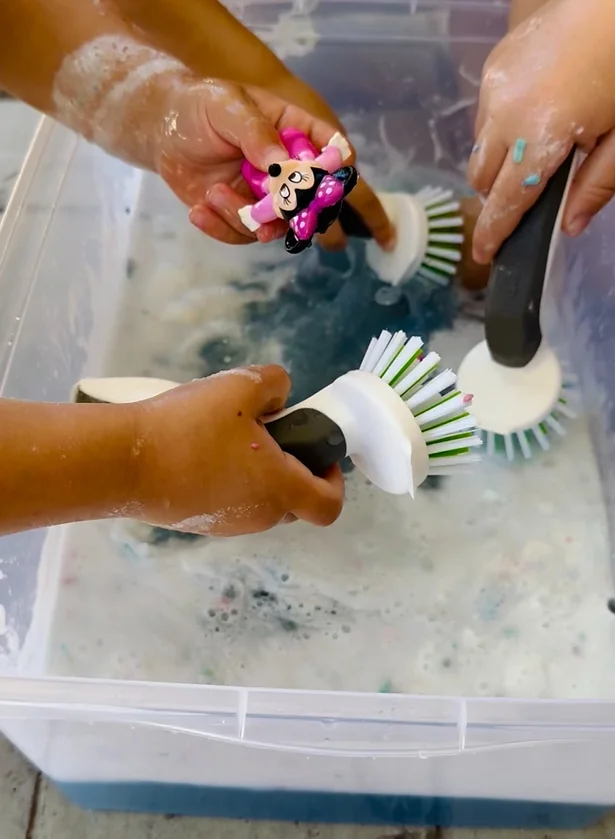 Kids washing the shaving cream off the LEGOs