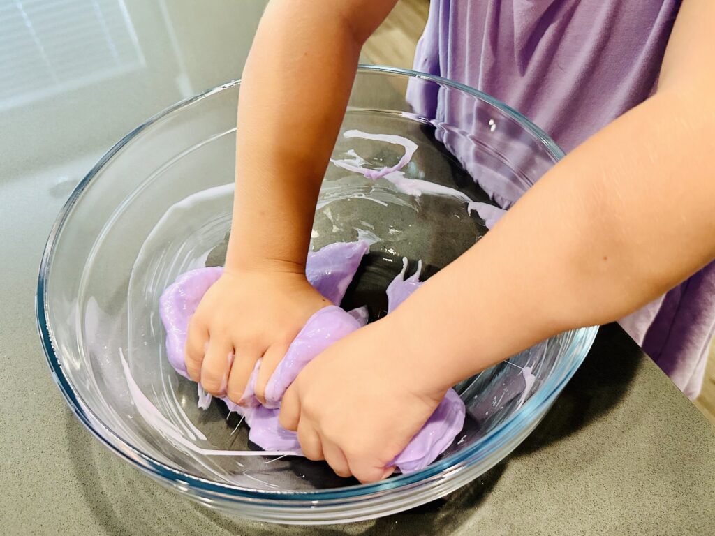 Child kneading the homemade slime ingredients.